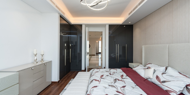 Elegant master bedroom with oak wood detailing and designer furnishings in OAK Townhouses.